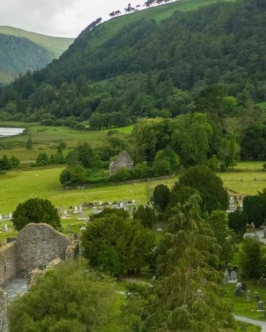 An aerial view of an ancient church and round tower