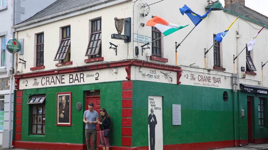 People standing outside of the Crane Bar in County Galway.