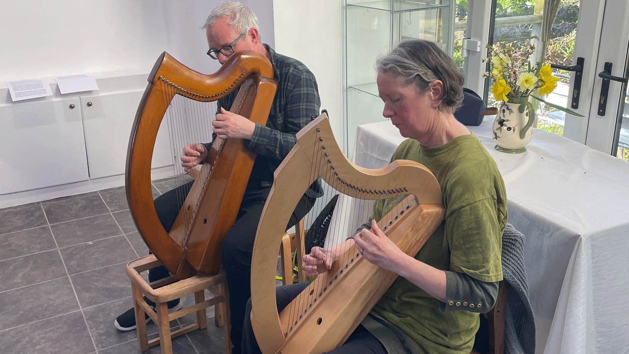 Two people playing harp at the Teach Ban Gallery