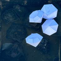 Looking down at 4 pale blue diamond shapes on dark square background.