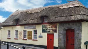 The exterior of the Cashel Folk Village with its thatched roof