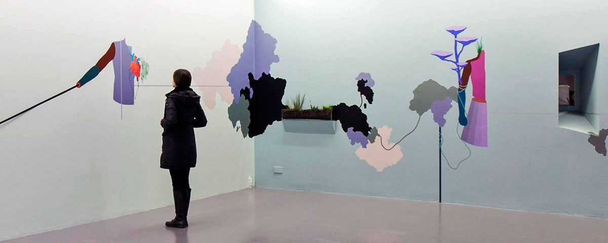 A person admiring some wall art in the gallery