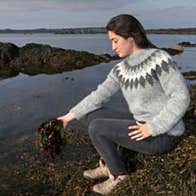 A person foraging for seaweed in the sea.