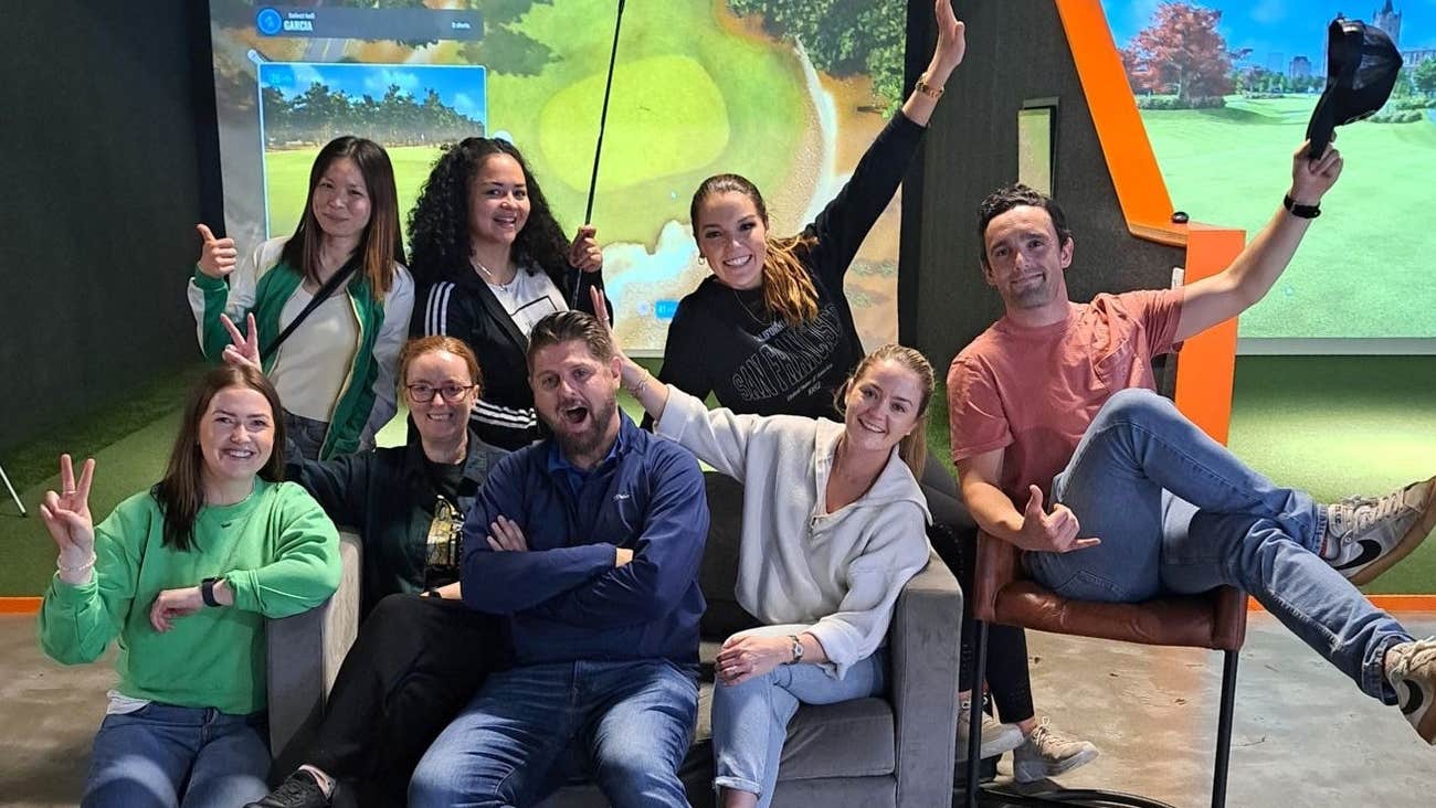 Group of people sitting and standing in front of a screen