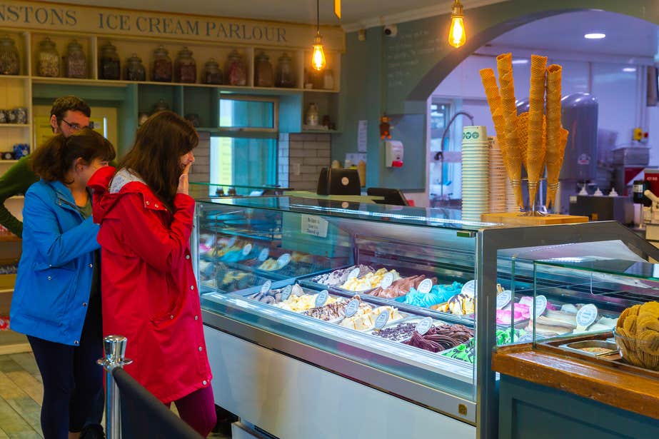 Three people browsing ice-cream flavours at Mammy Johnston's ice-cream parlour in Strandhill, County Sligo