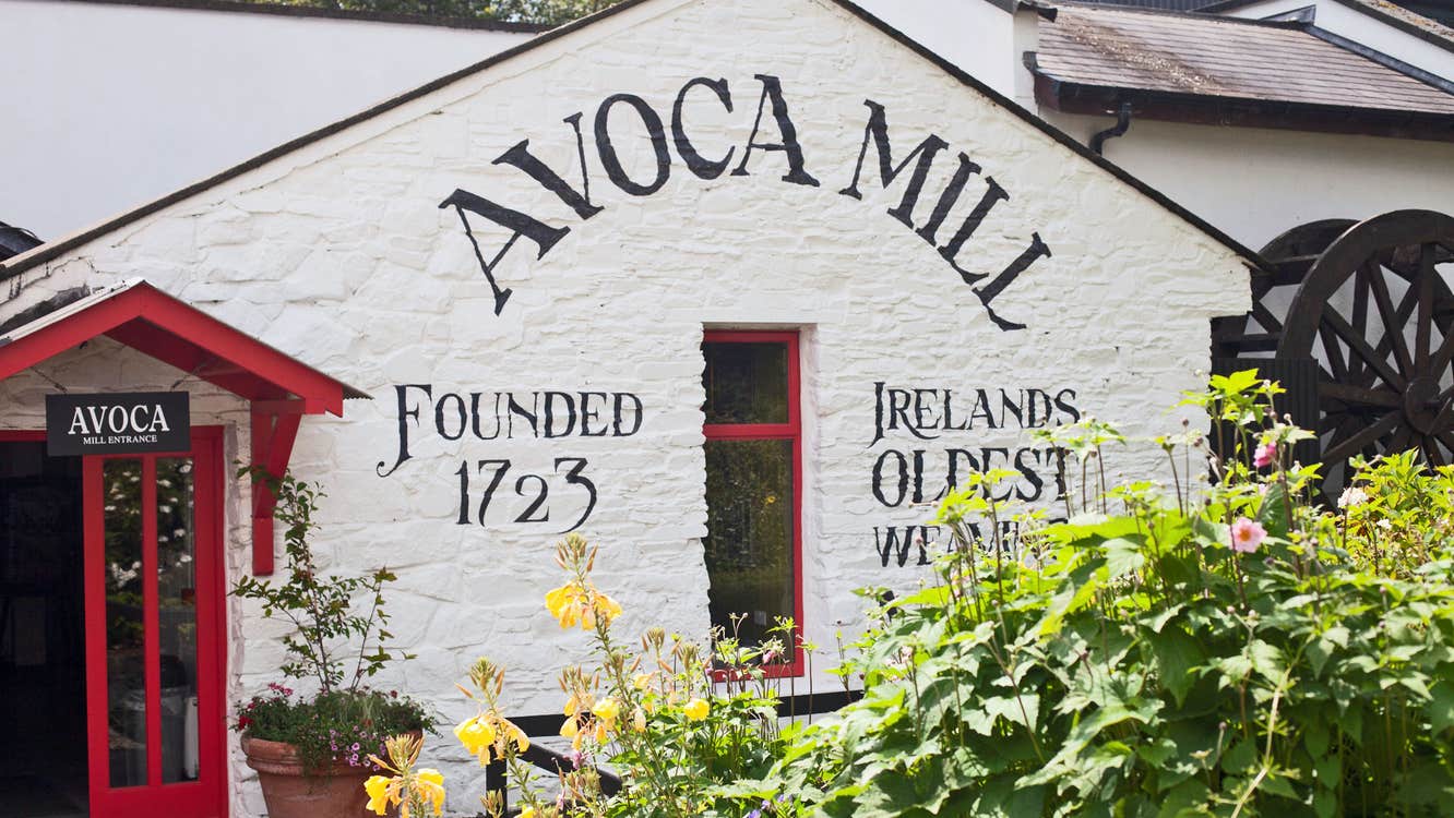 Avoca Mill exterior painted white with a date of 1723 and a water wheel