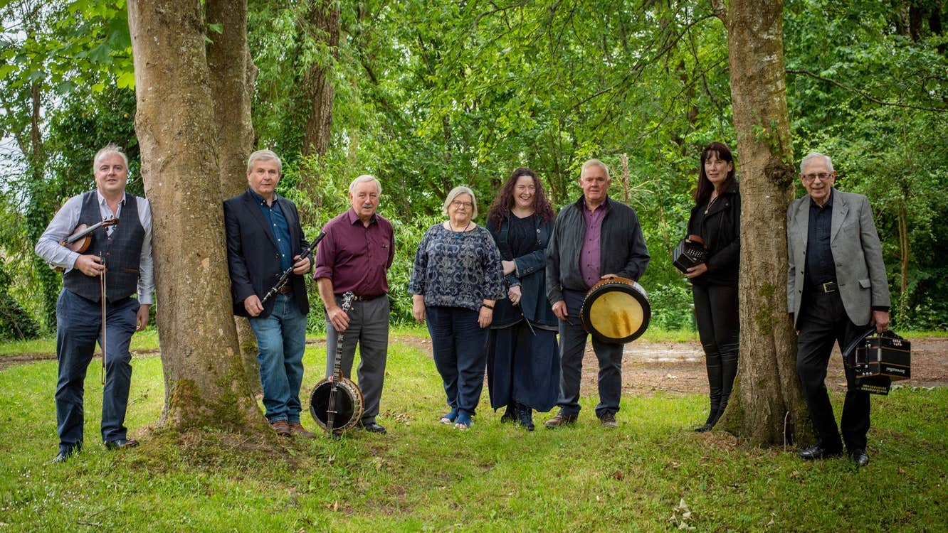 The members of Shaskeen, standing amongst some trees.