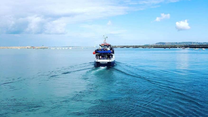 A cruiser out on Dublin Bay on a clear day with blue skies