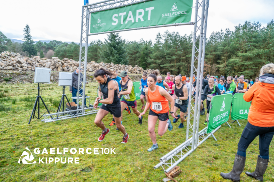 You will set off with the siren to embark on your Gaelforce 10K Kippure experience. Start line through small, metal frame archway, trees in the background.