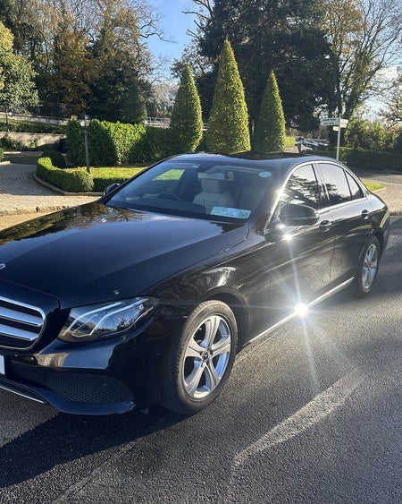 A gleaming limousine parked on a quiet residential street