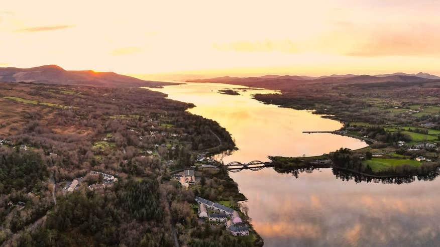 An aerial view of Kenmare with a bridge, houses and a river in the background