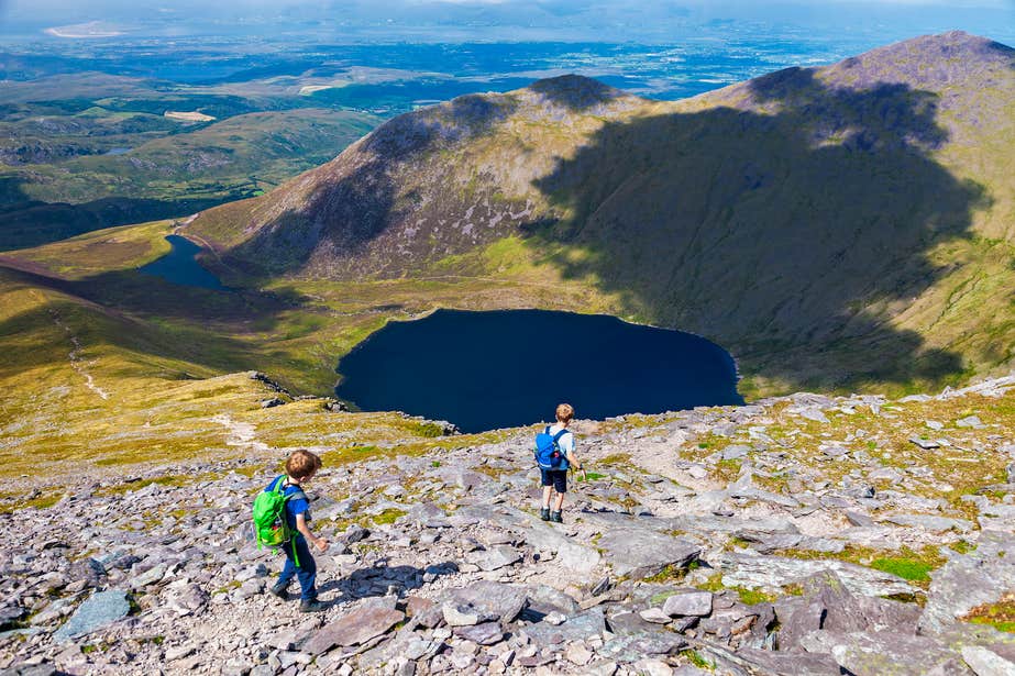 Two boys walking the mountain face of Carrauntoohil in County Kerry.