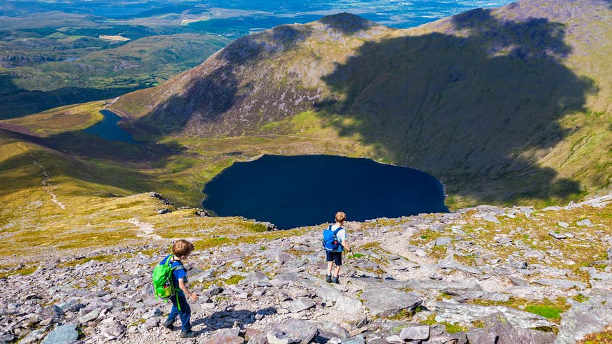 Two boys walking the mountain face of Carrauntoohil in County Kerry.