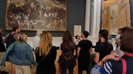 Group listening to a tour guide inside a room in an art gallery