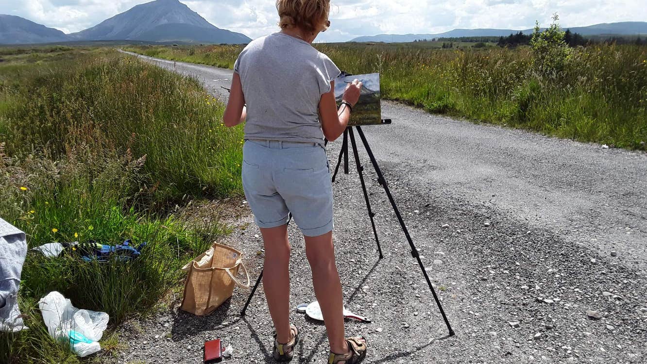 Woman painting the scenery at Gaeltacht Thair Thir Chonnaill in County Donegal