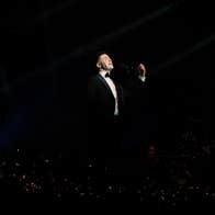 Eamonn Walsh in a suit, singing in a black void.