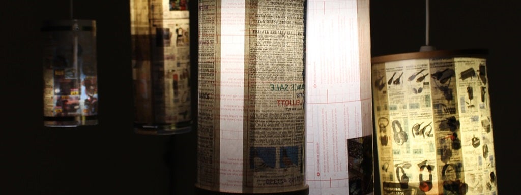Detail of work by Cillian Finnerty. Several lamps with custom shades made from newspaper and magazine pages.