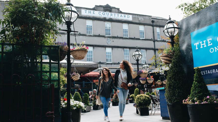 Two women strolling through The Courtyard in Cork City.