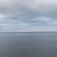 Richie Stokes, The Flaggy Shore, a view across a large open calm expanse of water with cloudy sky