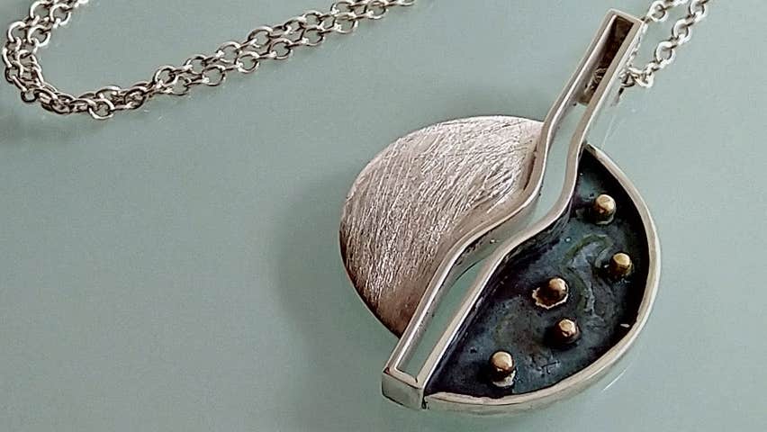 A round gold and silver pendant