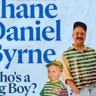 Smiling man in stripy top and cap with small boy in the same outfit.