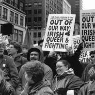 Black and white photo of people in a demonstration holding up signs