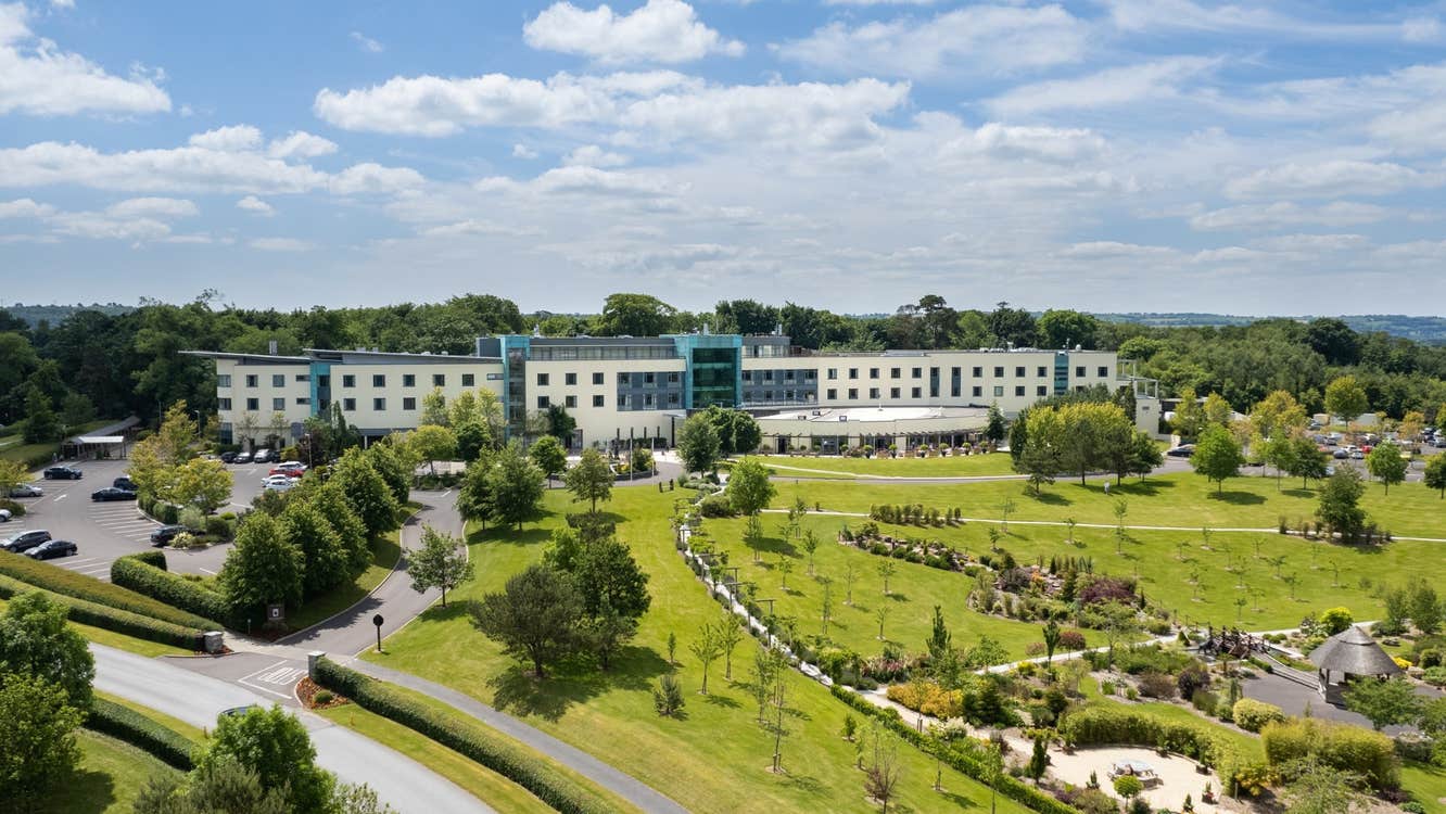 Exterior of hotel in mature gardens.