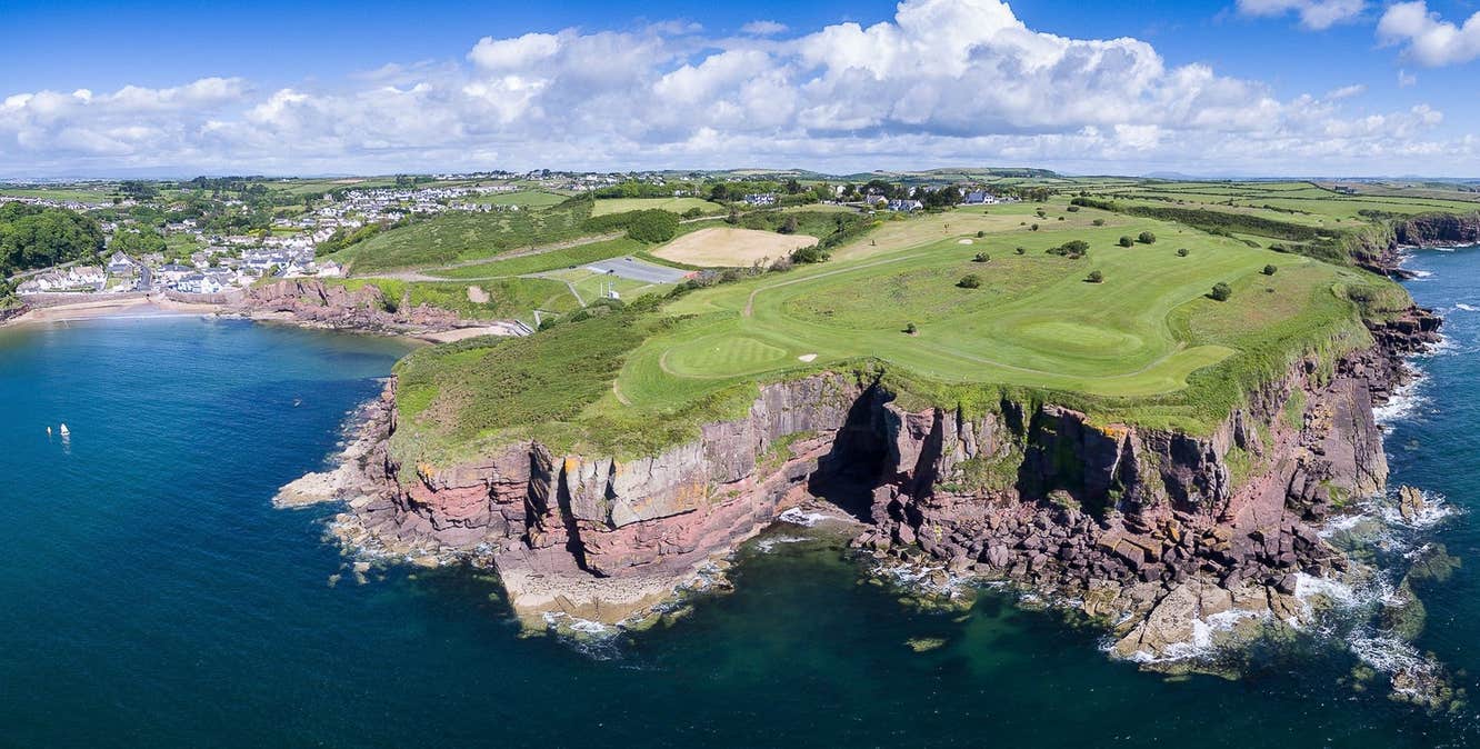 Golf course with cliffs the sea and a beach to the left