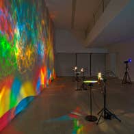 Colourful light show projected on a wall in a gallery