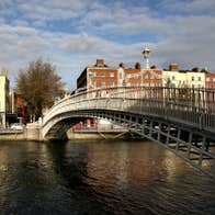 Bridge over a river with a tree and red brick and cream buildings in the background