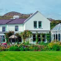 A front lawn flowers and shrubbery around the exterior of Cashel House Hotel