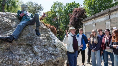 A male tour guide giving a tour to a large group of people