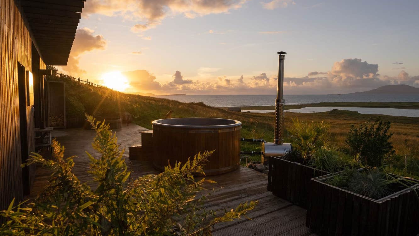 The hot tub with sea view and sunset in the background