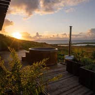 The hot tub with sea view and sunset in the background