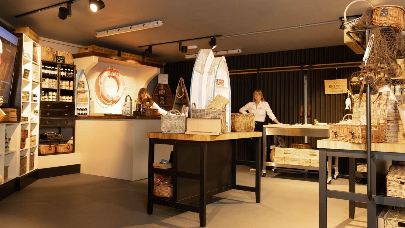 Two people standing at the back of a shop surrounded by products