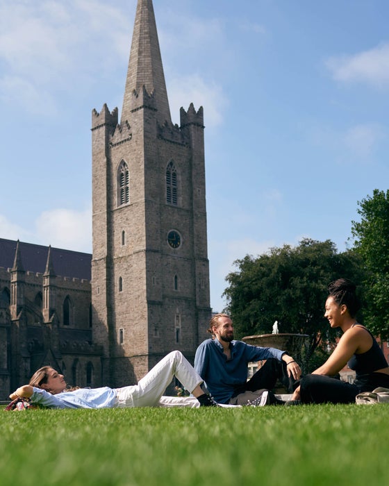 People laying on the grass in front of St Patrick's Cathedral in Dublin city
