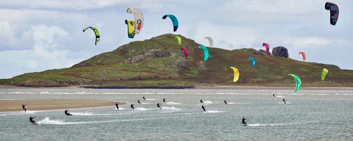 A large group of kitesurfers taking part in kitesurfing in the bay with Pure Magic Kitesurfing Dublin