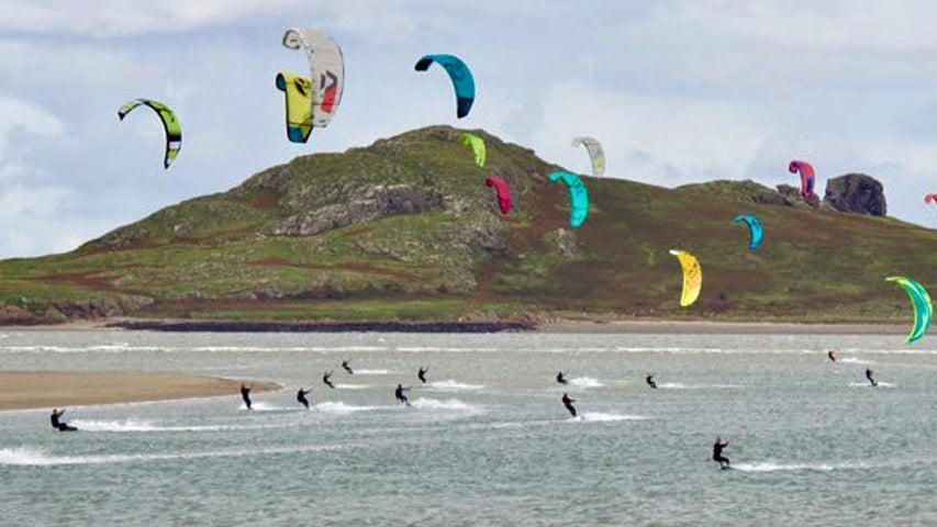 A large group of kitesurfers taking part in kitesurfing in the bay with Pure Magic Kitesurfing Dublin