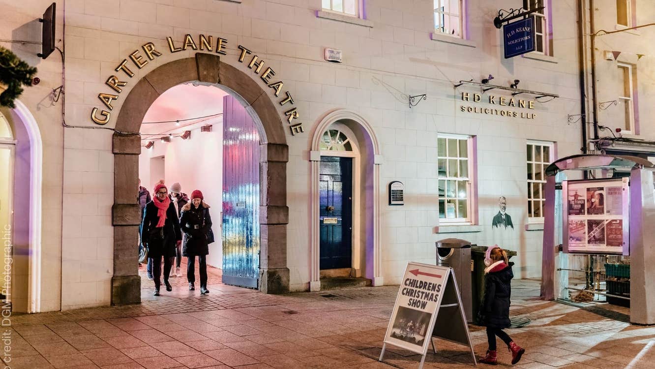 An arched entrance with people coming through it