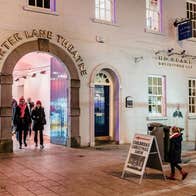 An arched entrance with people coming through it
