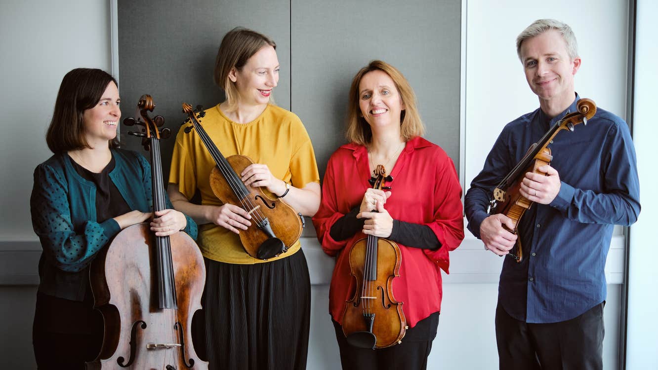 The members of the Solas Quartet smiling and holding your instruments.