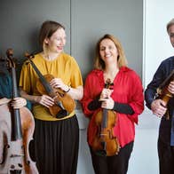 The members of the Solas Quartet smiling and holding your instruments.