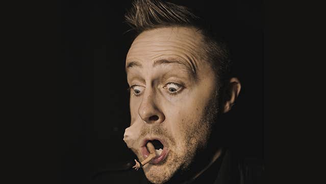 The legendary Keith Barry brings his mind blowing show, Mind Games, back to Wexford Spiegeltent Festival 2024. Head view of man looking shocked with tiny person in his mouth pushing out his cheek.