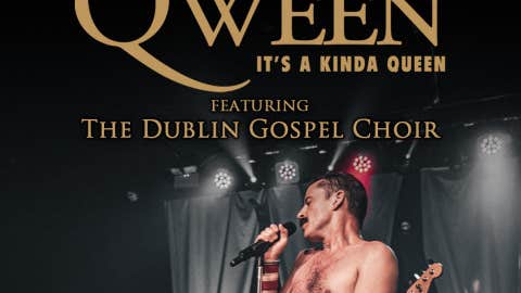 A bare chested man singing with a mic on a stage.