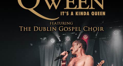 A bare chested man singing with a mic on a stage.