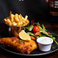 A plate with fish and chips garnished with a salad