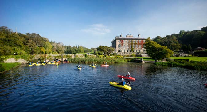 A group of people kayaking in front of Westport House, Mayo