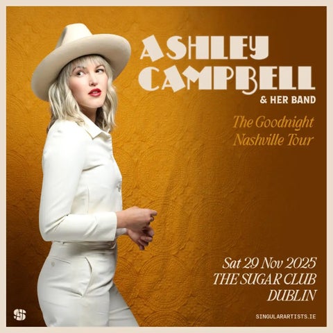 Side view of a woman dressed in white top, jacket and cowboy hat against dull orange background.