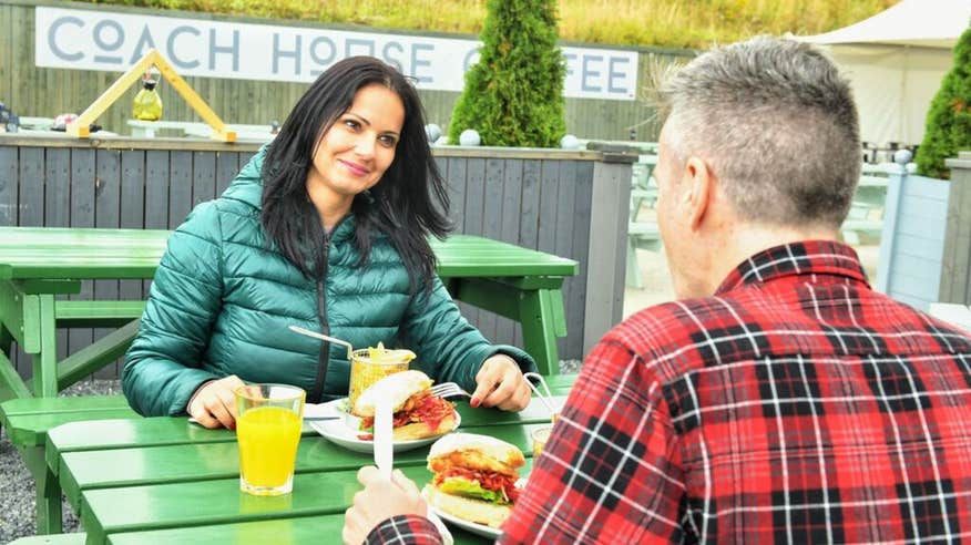 Two people eating a meal outside at Coach House Coffee