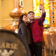 Pearse Lyons Distillery interior with couple taking selfies by the pot stills